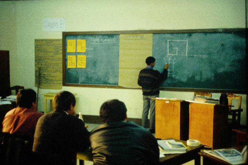 In einem einfachen Klassenzimmer steht ein Lehrer an der Tafel und erklärt die vier Zahlsymbole der andinen Philosophie: Die Eins ist eine Spirale, die die kosmische Bewegung symbolisiert. Die Zwei ist eine Doppelspirale, denn alles drückt sich in einem Paar komplementärer Gegensätze aus. Dies Drei ist eine weitere Spirale, ein Impuls, um die Entwicklung des Lebens zu sichern. Die beiden Spiralen der Vier repräsentieren die Kraft der Komplementarität auf der Suche nach totaler Harmonie. Der Lehrer zeigt, wie man mit den Methoden der exakten Wissenschaften, in diesem Fall dem kartesischen Plan, der Symmetrie der Achse und des Punktes, diese Zahlsymbole exakt konstruieren kann.